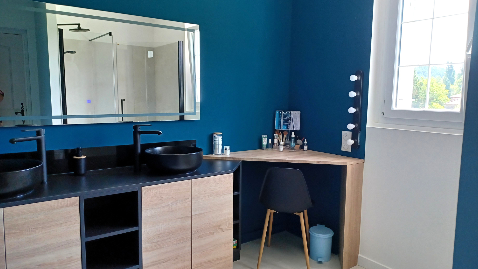 Une salle de bain avec comme couleur le bleu canard.